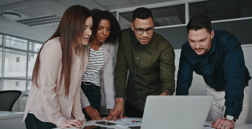 Group of smart young multiethnic businesspeople discussing ideas while looking at laptop computer